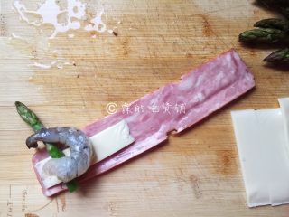 8、培根芝士烤虾卷,随后用一片培根，放上芝士、虾，芦笋尖，卷起。