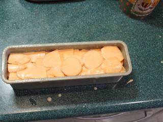 7、千层地瓜蛋糕,将地瓜片层层迭迭的摆入烤模。如果烤模底部不能分离,要垫上一层烤盘纸才容易脱模。