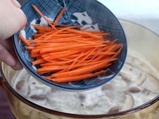 7、香菇滑鸡粥,然后再把胡萝卜丝也放进去，搅拌均匀后按照个人口味调入适量的盐煮约五分钟。