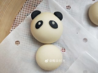13、卡通馒头—小熊猫馒头,用手压扁一点，粘在面团上做它的眼睛。然后用白色面团做一个很小很小的圆粘上去做眼珠。