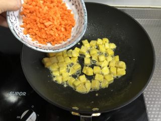 7、黄金馒头粒,倒入胡萝卜丁翻炒均匀