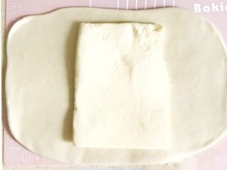 4、万能千层酥皮,面皮擀好后，从冰箱取出一片黄油，将黄油摆放在面皮的中间位置