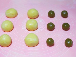 8、南瓜糯米球,将面团分成6份揉圆后压扁,莲蓉馅搓成6个圆球。