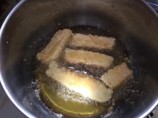 8、脆炸鲜牛奶,将牛奶条轻放入热油中炸至外表金黄即可捞出