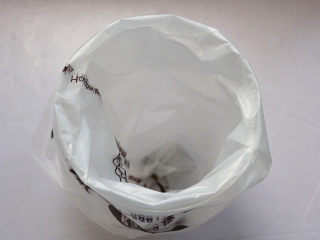 12、原味曲奇,用剪刀在裱花袋一端剪一个口，将裱花嘴放进裱花袋内部，将裱花嘴从尖端伸出，然后将裱花袋放入一个高装的杯子中。