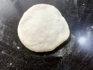 9、日式红豆包,取一个面团，正面向上，用擀面杖擀开，或者用手压扁都可以。