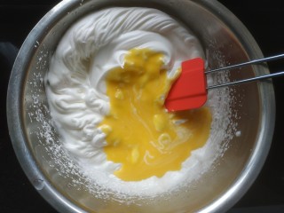 10、蛋糕卷,把蛋黄倒入三分之一搅拌均匀