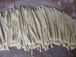 5、牛轧糖沙琪玛,擀成厚度2毫米的片,再切成宽度2毫米的条,切的时候也要撒少许玉米淀粉放沾