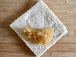 9、吐司苹果派,在未划刀口的一边放入苹果酱