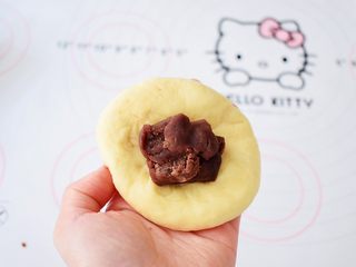 8、面包豆沙卷,取一个面团擀成中间厚四边薄的面片，放入豆沙，像包包子那样包好按扁