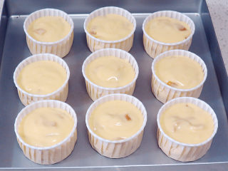 13、制做简单快捷的下午茶点心【酸奶芒果干麦芬】,将蛋糕糊装入模具中，八分满左右。可做9个麦芬蛋糕