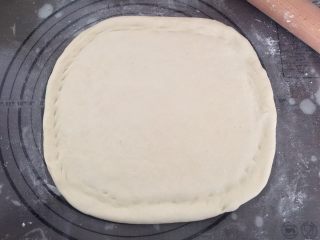 6、龙虾披萨,取出发酵后的压扁排气后松弛一会，再擀开成长方形状，用手指把四边捏高点