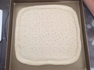 7、龙虾披萨,把饼胚放入烤盘里，在中间扎上小孔