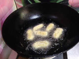 13、脆皮炸鲜奶,锅里倒入适量油烧至六成热，将挂满糊的奶块逐个放进去炸到表面金黄