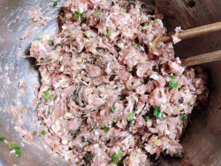 9、梅干菜烧饼,将肉馅顺时针搅拌均匀。