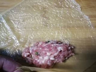 4、炸响铃,用四分之一张豆腐衣平铺在案板呈菱形状，在对角处放上适量肉糜。