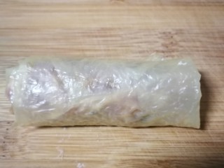 5、炸响铃,像包春卷一样把豆腐衣小心包裹起来，包得紧一点，包好口朝下放置，防止散开。也可以在开口处用湿淀粉封口，但个人觉得效果不好干皮也封不太住，还是口朝下摆放比较好。