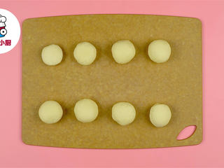 3、零难度脆底蜂蜜小面包,取出面团稍微按揉排出多余气体，搓成长条，分割成8等份搓圆，再盖上保鲜膜静置松弛15分钟