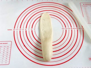 10、牛奶炼乳蔓越莓软欧,用擀面杖从面团的中间往上擀开。