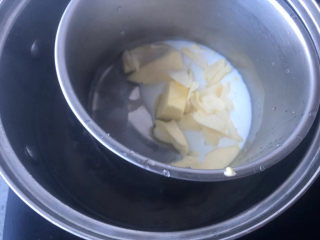 4、黄油中空戚风,牛奶里加入黄油，再把盆坐到开水里，隔水加热到60度左右，黄油融化。