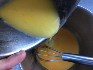 5、黄油中空戚风,趁热把奶液倒入蛋黄盆中，一点一点加。