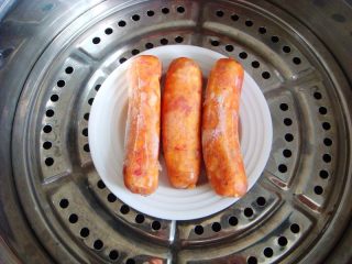 5、＃甜味＃暖暖熊香肠烧果子,利用这个空档把香肠入蒸锅蒸15分钟。