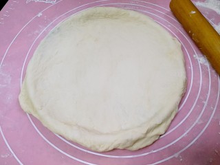 6、榴莲披萨,烤箱预热180度。把面饼覆盖在披萨盘上。