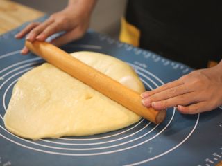 6、蜂蜜椰蓉小面包,6.将面团气体排出，面团分割成每个重70克左右的小面团，搓圆盖上保鲜膜松弛5~10分钟。