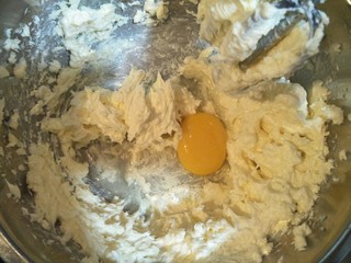 6、鲜花芝士蛋糕,奶油奶酪室温软化后加入糖用电动打蛋器搅拌顺滑后加入一个鸡蛋搅拌均匀。