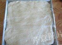 6、尼可拉可颂,将面团取出，在一个平盘中摊平，盖上保鲜膜，入冰箱冷冻1小时（以延缓面团发酵）