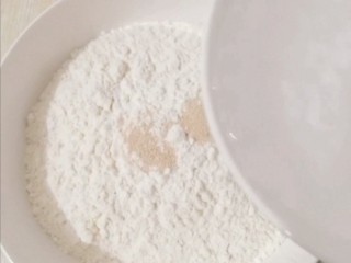 2、葱花发面小饼,面粉放入盘里，加入酵母粉和白糖d倒入清水