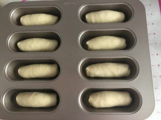 9、元气早餐之热狗餐包,装入模具。在温度37度，湿度75%的环境中进行最后发酵，发酵至8分满时取出，表面涂全蛋液，洒芝麻装饰