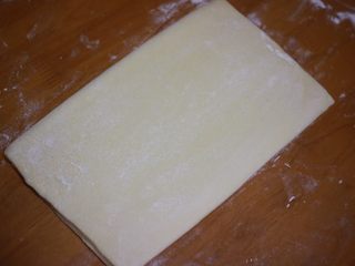 6、丹麦手撕吐司,再将面团对折，完成第一次四折，然后将面团盖好保鲜膜放冰箱冷藏松弛二十分钟，这样可以更好的擀开