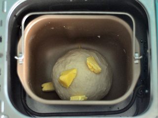 5、黑芝麻吐司,揉至面筋扩展，表面光滑，加入软化的黄油，选择揉面程序20分钟。