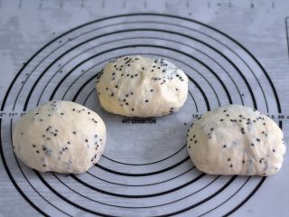 8、黑芝麻吐司,将芝麻轻轻揉进面团后，面团均分成三团，盖上保鲜膜松弛15分钟。(加芝麻这个过程，可以放在结束揉面程序前3分钟放入面包机，我因为忘记了，才在这