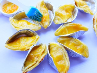 8、网红蛋挞皮芒果酥,在蛋挞皮上面刷上一层蛋奶液。