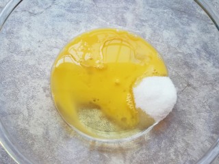 3、麦片芝麻核桃酥,盆里倒入蛋液、玉米油和细砂糖。