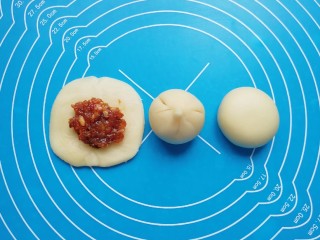 16、冬至美食  鲜肉酥饼,放上肉馅，用虎口慢慢向上推挤收口，将收口捏紧，反过来收口朝下摆放，用手掌轻轻压平成饼状。