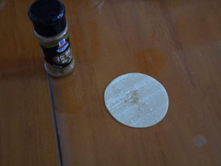 4、????超快手零失败的饺子皮版葱油饼,取一张饺子皮，刷上一层油，倒入少许的孜然粉