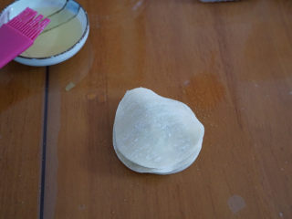 7、????超快手零失败的饺子皮版葱油饼,再刷上一层油，同样撒少许葱花，重复以上操作，共6张饺子皮。