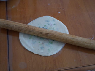 8、????超快手零失败的饺子皮版葱油饼,用擀面杖将饼皮擀成大簿圆片。