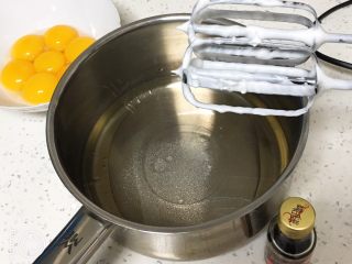 4、10寸咖啡戚风蛋糕,玉米油和清水混合，加入盐和20克的细砂糖，用打蛋器低速搅拌均匀。