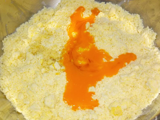 4、兰姆葡萄夹心饼乾,再加入蛋黄液与兰姆酒，继续搓揉至成团