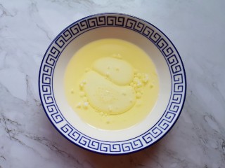 2、蔓越莓玛德琳蛋糕,将牛奶和玉米油倒入小碗里。