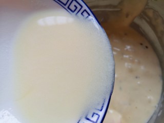 8、蔓越莓玛德琳蛋糕,顺着盆边加入混合好的牛奶和玉米油，翻拌均匀，装进裱花袋。