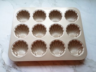 9、蔓越莓玛德琳蛋糕,烤箱上下管170度预热。玛德琳模具里面抹上一层黄油。