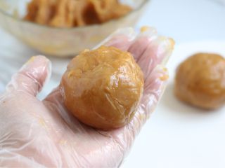 11、烤菠萝鸡肉汉堡,戴上手套，手掌抹上些许油，取100克左右的鸡肉泥，捏成团。在双手掌之间来回扔几次。