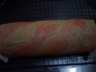 14、圣诞蛋糕卷,后用擀面杖将奶油顺着油纸卷起来，放入冰箱冷藏2小时定型即可了