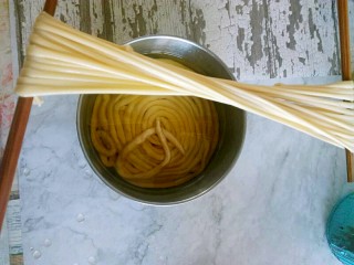 11、馓子,用两只筷子撑起来，轻轻的拉长后准备下锅油炸。