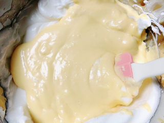 15、酸奶芝士蛋糕,用刮刀把蛋白和芝士糊拌匀。将蛋白和芝士糊拌匀以后,全部倒回蛋白碗里。